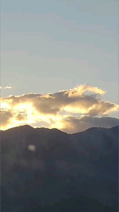 The clouds roll in behind the mountains.
The sky is cool grey like blue.
The…